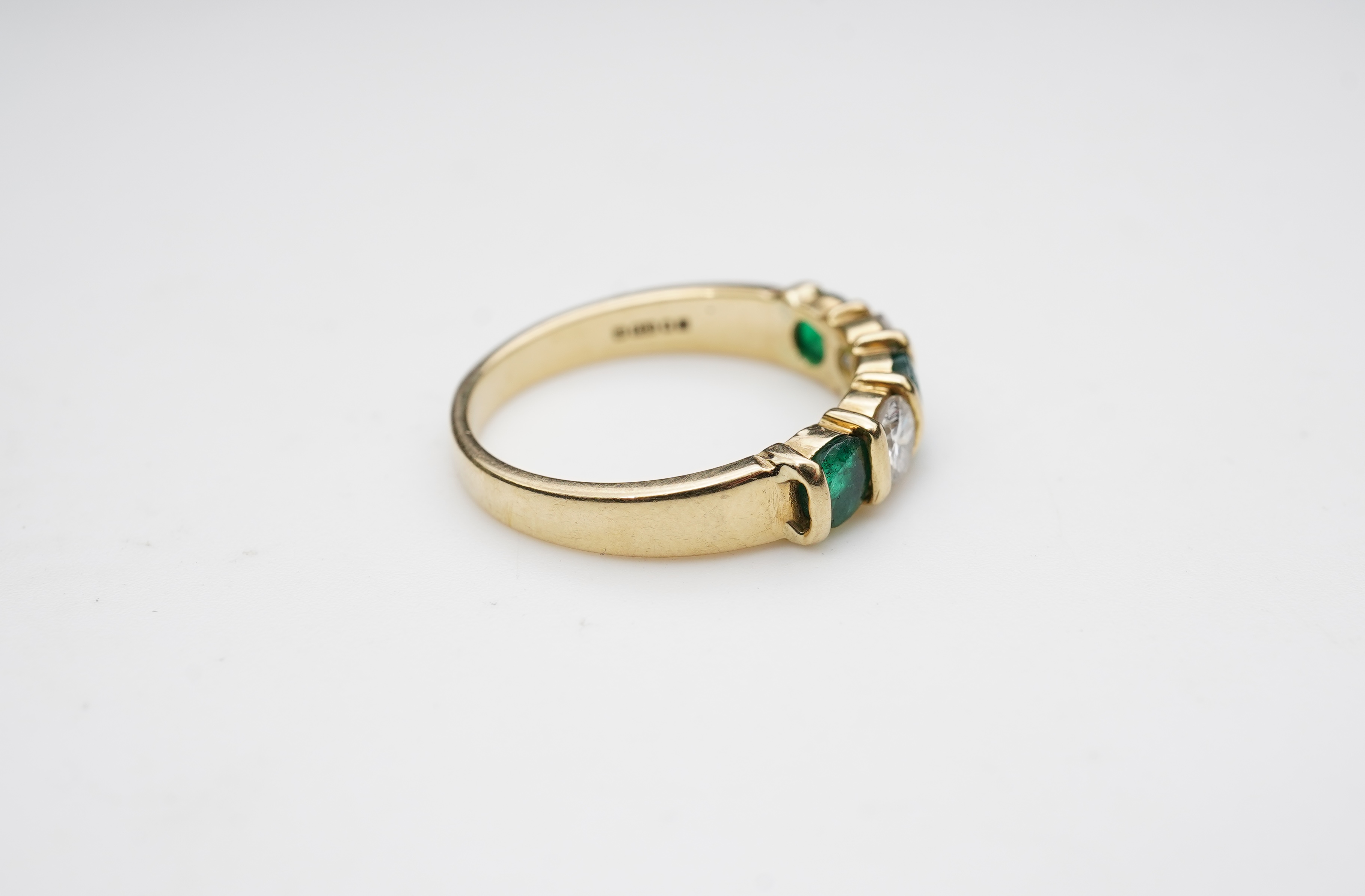 An emerald and diamond five-stone ring